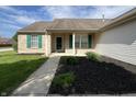 Inviting front entrance with brick accents, green shutters, and landscaped flower beds at 948 Kitner Ave, Avon, IN 46123