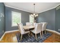Dining room with wood table, upholstered chairs, elegant chandelier, and natural light from windows at 10144 Water Crest Dr, Fishers, IN 46038
