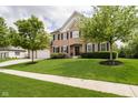 Beautiful home with brick facade, black shutters, lush lawn, mature trees, and a two-car garage at 10144 Water Crest Dr, Fishers, IN 46038