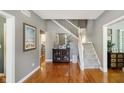 Inviting foyer with hardwood floors, staircase, decorative mirror, and view into other rooms at 10144 Water Crest Dr, Fishers, IN 46038