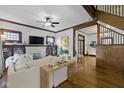 Bright living room with hardwood floors, white fireplace, ceiling fan, and original trim at 1132 Evison St, Indianapolis, IN 46203