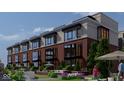 Elegant townhomes with brick accents, expansive windows, green space, and outdoor seating areas at 11940 Citywalk Dr, Fishers, IN 46038