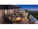 Relaxing rooftop terrace with comfortable seating, fire pit, grill, and beautiful city views at 11940 Citywalk Dr, Fishers, IN 46038