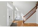 Bright foyer featuring hardwood floors, staircase with wood railing, and a front door with sidelight windows at 12409 Dellfield W Blvd, Carmel, IN 46033