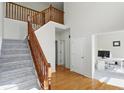 Light-filled foyer boasts hardwood and carpeted stairs, with an open view into an adjacent office space at 12409 Dellfield W Blvd, Carmel, IN 46033