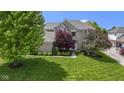 Lovely two-story home showcasing mature trees, a well-manicured lawn, and tasteful landscaping at 14094 Pecos Ct, Carmel, IN 46033