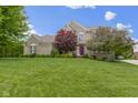 Charming two-story brick home featuring a well-manicured lawn and mature landscaping at 14094 Pecos Ct, Carmel, IN 46033