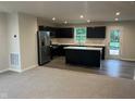 Modern kitchen featuring sleek black cabinetry, stainless steel appliances, and a center island with sink at 1684 Bayberry Dr, Greenfield, IN 46140