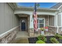 Inviting front porch with brick accents, cozy seating, and a charming front door at 1701 Summerwood Blvd, Greenfield, IN 46140