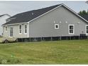 Exterior side and back view of a gray home with black roof and grass backyard at 1730 Juniper Ln, Greenfield, IN 46140