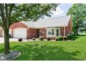 Well-manicured lawn and mature trees surround this inviting brick home with a bay window at 194 Waterford Ct, Avon, IN 46123