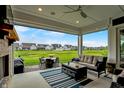 Enjoy the view overlooking the golf course from the covered patio with comfortable seating and a fireplace at 20010 Prescott Pl, Westfield, IN 46074