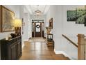 Bright foyer features hardwood flooring, elegant lighting, and a view of the decorative front door at 20010 Prescott Pl, Westfield, IN 46074