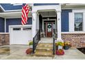 Inviting entryway features a decorative front door, beautiful landscaping, and an American flag at 20010 Prescott Pl, Westfield, IN 46074