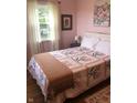Bright bedroom features a floral-themed quilt, wood flooring, and a window that offers natural light at 21749 Oak Ridge Rd, Sheridan, IN 46069