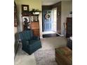 Inviting living room showcasing a cozy blue chair, hardwood floors and a bright entrance with a blue door at 21749 Oak Ridge Rd, Sheridan, IN 46069
