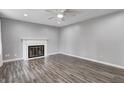 Living room with gray walls, ceiling fan, wood floors and a decorative fireplace with white mantle at 2228 Dover St, Anderson, IN 46013
