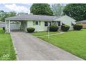 Quaint single-story home featuring a covered carport and mature landscaping at 2840 W 12Th St, Anderson, IN 46011