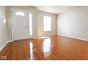 Bright living room features wood floors, neutral paint and a large front door at 3059 Black Forest Ln, Indianapolis, IN 46239