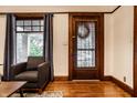 Inviting room with a dark-wood-trimmed door, window and hardwood flooring at 309 N Riley Ave, Indianapolis, IN 46201