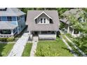 Aerial view of a well-maintained property with a charming front porch and green surroundings at 344 N Whittier Pl, Indianapolis, IN 46219