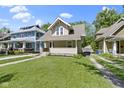 Quaint home with a spacious, green front lawn, covered front porch and an inviting exterior at 344 N Whittier Pl, Indianapolis, IN 46219