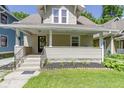 Inviting front porch with classic design elements, complemented by a well-manicured lawn at 344 N Whittier Pl, Indianapolis, IN 46219