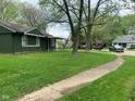 Residential street view with a single-story home surrounded by lush greenery at 3742 N Wittfield St, Indianapolis, IN 46235