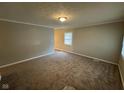 Cozy living room featuring neutral walls, plush carpet, and ample natural light at 3742 N Wittfield St, Indianapolis, IN 46235