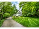 Charming white two-story home surrounded by lush green lawn and mature trees at 4410 N Pennsylvania St, Indianapolis, IN 46205