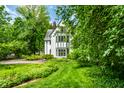 Charming white two-story home surrounded by lush green lawn and mature trees at 4410 N Pennsylvania St, Indianapolis, IN 46205