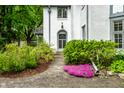 Elegant arched front door with a brick walkway and blooming flower bed at 4410 N Pennsylvania St, Indianapolis, IN 46205