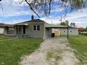Back view of home with car port and garage, a spacious gravel driveway, and a well-kept yard at 453 Illinois St, Fortville, IN 46040