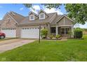 Charming brick home featuring a two-car garage, well-manicured lawn, and inviting curb appeal at 4907 Franklin Villas Pl, Indianapolis, IN 46237