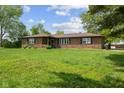 Brick home with well-manicured front lawn, landscaping, and mature trees at 522 E County Road 1000 S, Clayton, IN 46118