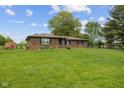 Brick house with a large lawn and mature trees under a blue sky at 522 E County Road 1000 S, Clayton, IN 46118