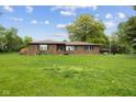 Lovely brick home with green lawn, blooming flowers, and mature trees at 522 E County Road 1000 S, Clayton, IN 46118