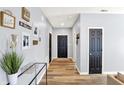 Hallway decorated with art, leading to black paneled doors and hardwood floors at 5554 Jona Way, Bargersville, IN 46106