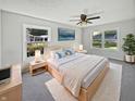 Cozy main bedroom featuring neutral colors, two windows, ceiling fan, and carpet flooring at 616 W Michigan St, Greenfield, IN 46140