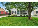 Charming home featuring a screened porch, stone accents, and a well-maintained lawn at 6176 Kingsley Dr, Indianapolis, IN 46220
