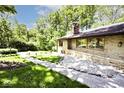 Landscaped front of a stone home with a view of the lush lawn and surroundings on a sunny day at 6248 Graham Rd, Indianapolis, IN 46220