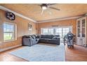 Cozy living room with hardwood floors, a gray sectional, wood paneled ceilings, and great natural light at 671 W 350 N, Shelbyville, IN 46176