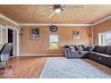 Inviting living room with hardwood floors, wood paneled ceilings, neutral paint, and a comfortable gray sectional at 671 W 350 N, Shelbyville, IN 46176