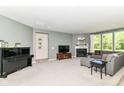 Spacious living area featuring a cozy fireplace, grand piano, and comfortable seating arrangement at 6832 Oakcrest Dr, McCordsville, IN 46055