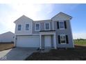 Charming two-story home with gray siding, white trim, an attached garage and a well-lit front porch at 7323 Waylon Way, Indianapolis, IN 46239