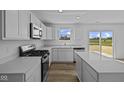 Bright kitchen featuring white cabinetry, stainless steel appliances, and a center island at 7323 Waylon Way, Indianapolis, IN 46239