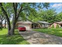Lovely single-story home with a mature tree, brick facade, and a two-car garage at 8218 San Carlos Ct, Indianapolis, IN 46256