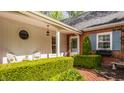 Inviting front porch with white columns, brick accents, trimmed bushes, and seating at 8770 N Pennsylvania St, Indianapolis, IN 46240
