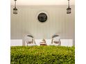 Charming front porch featuring vintage chairs, decorative lighting, and manicured boxwood hedges at 8770 N Pennsylvania St, Indianapolis, IN 46240