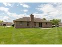 Rear exterior view of brick house with patio and large yard, perfect for outdoor living at 897 N Scott Dr, Greenwood, IN 46142